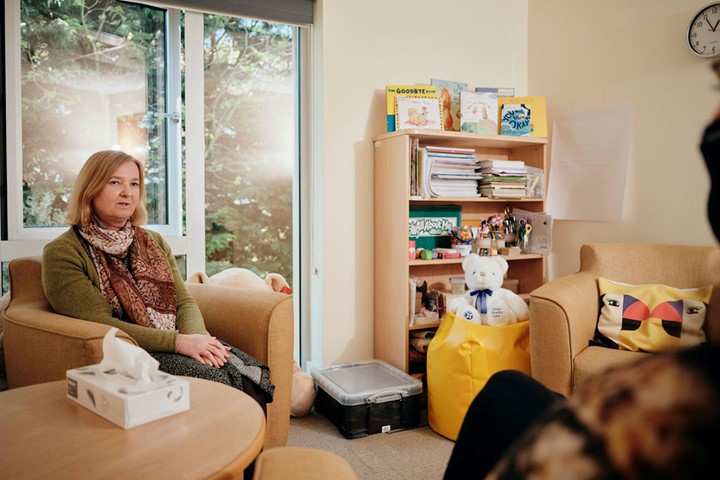 Image of bereavement counsellor talking to patient, box of tissues on table 