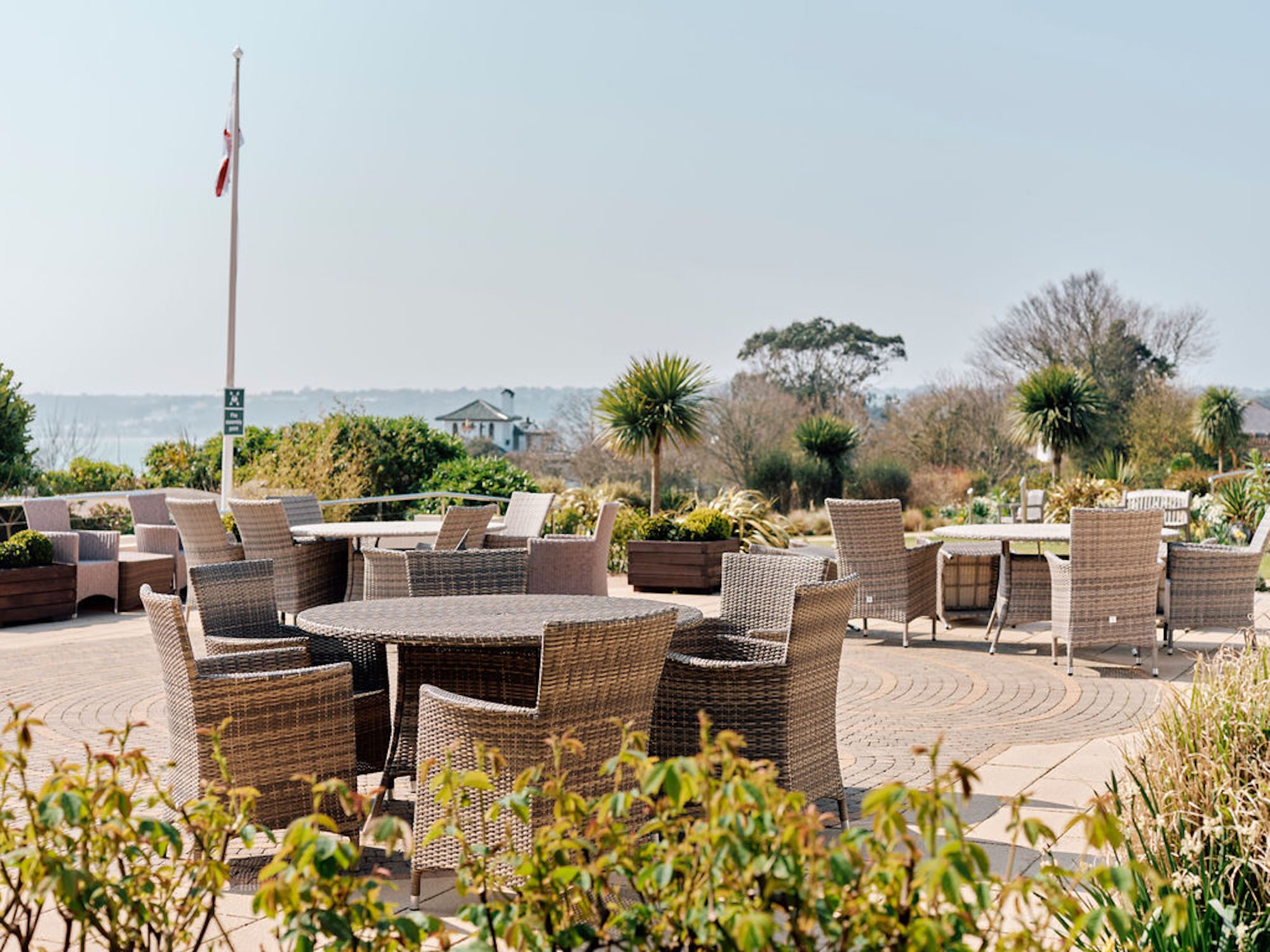 Image of tables and chairs in Hospice gardens with flag flying