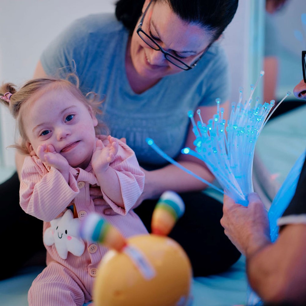Image of baby in sensory room with her parents 