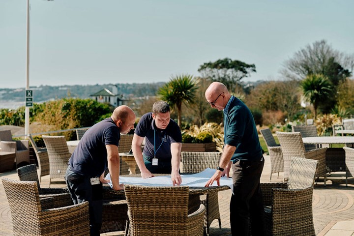 Image of staff members in Hospice gardens looking at document
