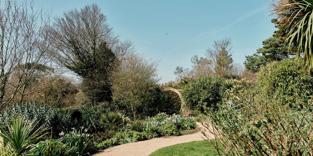 Image of pathway , grass and flowers in gardens at Jersey Hospice Care 
