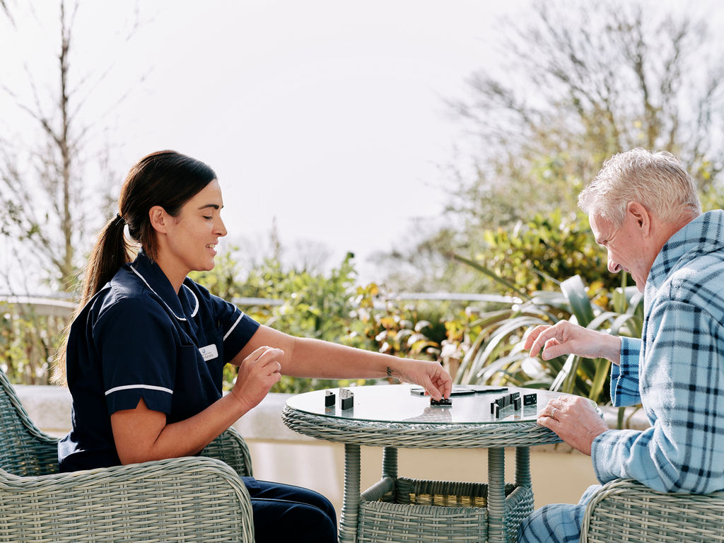 Nurse and patient playing dominoes