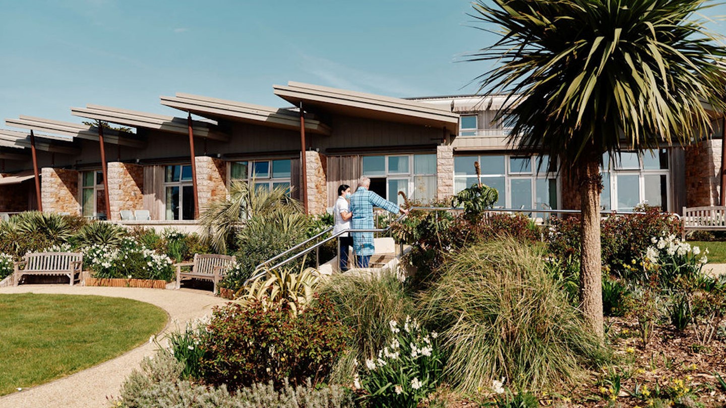 Image of nurse and patients on steps in gardens at Jersey Hospice Care