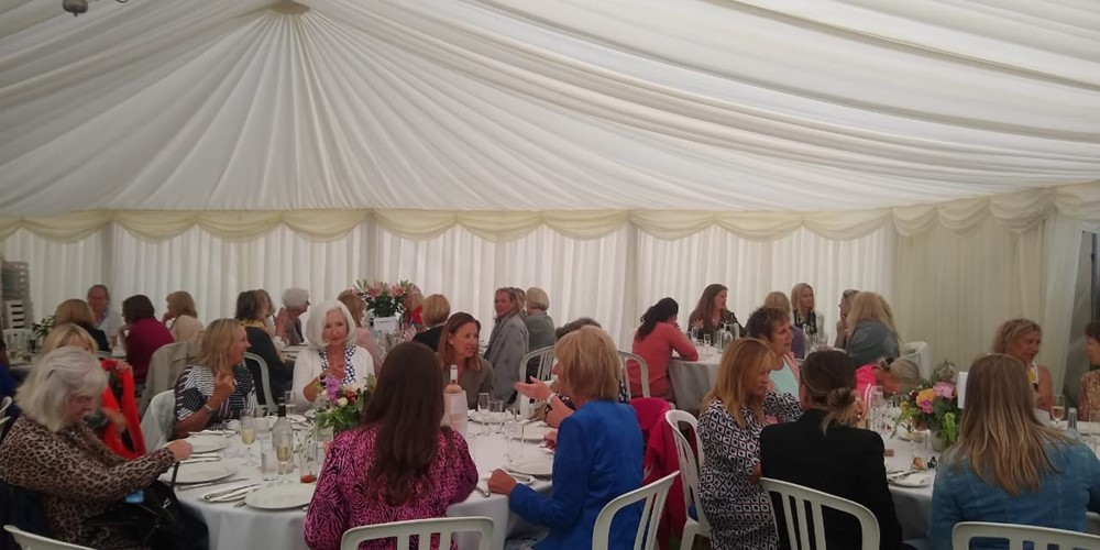 Image of ladies in marquee eating lunch 