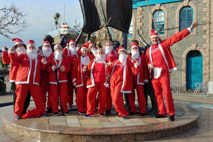 Image of group of people in Santa suits