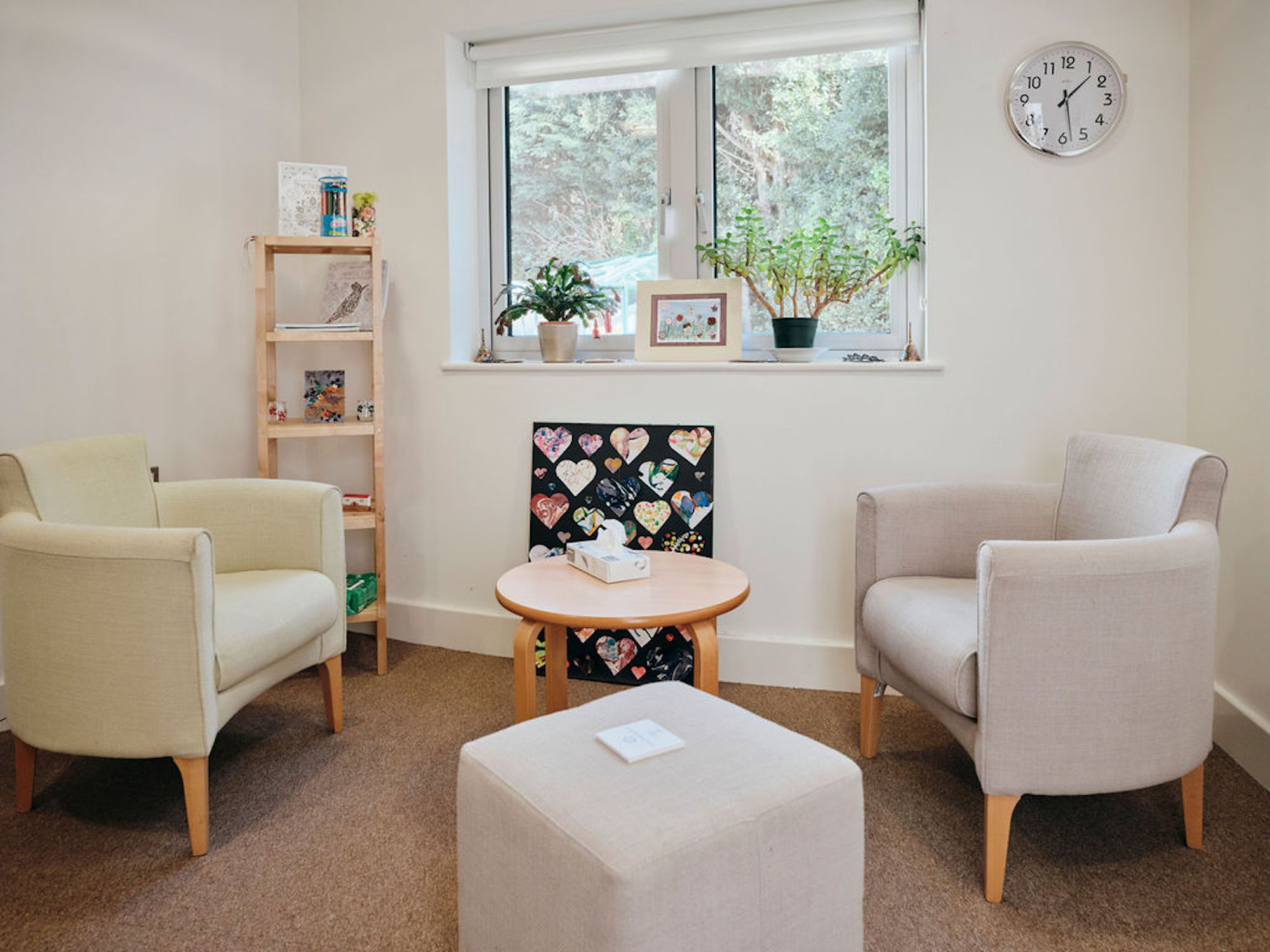 Image of bereavement counselling room, two chairs and a table with tissues on