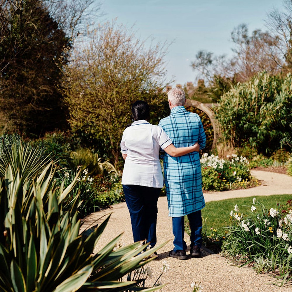 Image of nurse and patient walking in gardens at Jersey Hospice Care
